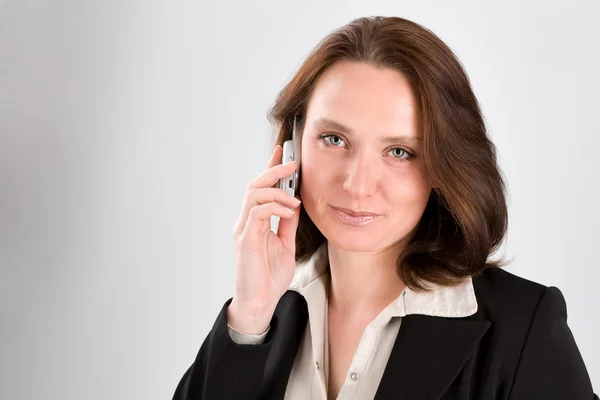 Woman speaks by phone on gray — Stock Photo, Image
