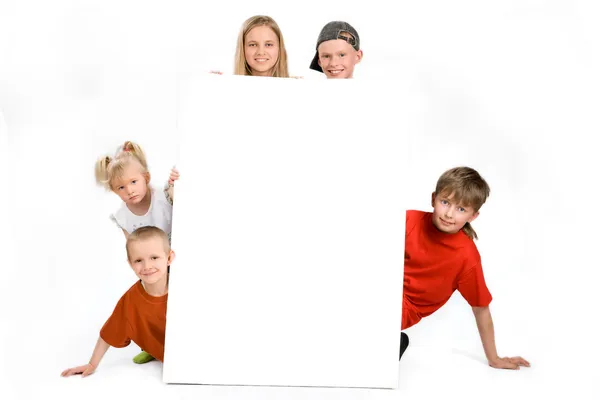 Groupe d'enfants derrière un panneau vierge Photo De Stock