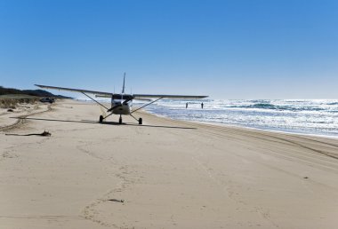 Airplane landing on the beach clipart