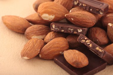 Almond nuts and pieses of milk chocolate clipart