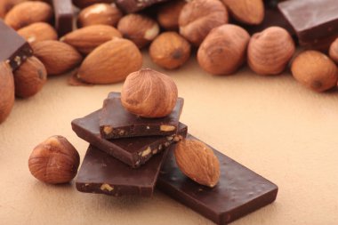 Almond nuts and pieses of milk chocolate clipart