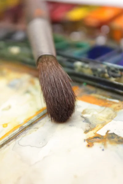 Goed gebruikte penseel in over paintbox — Stockfoto