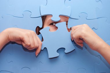 The girl spies through a blue puzzle clipart