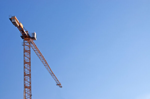 The elevating crane against the blue sky