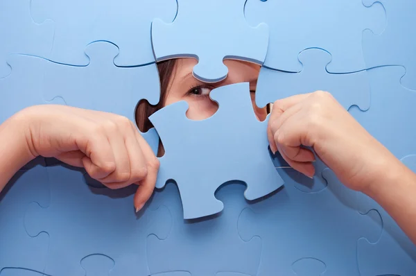 La fille espionne à travers un puzzle bleu — Photo