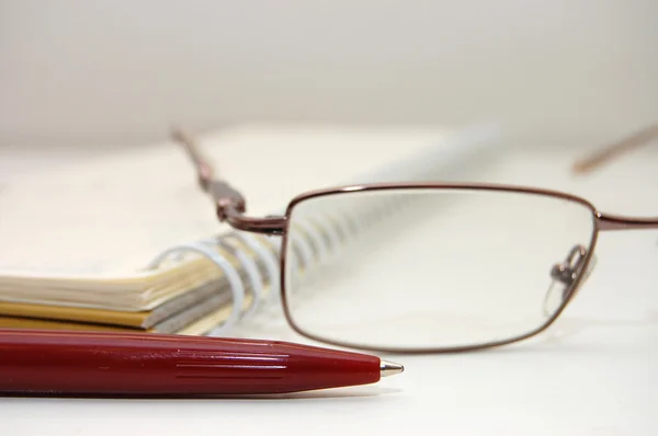 Glasögon och en penna på ark — Stockfoto