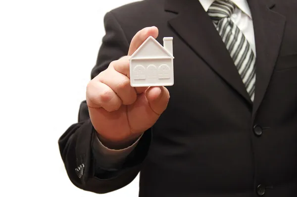 Man holding a small house in his hand — Stock Photo, Image