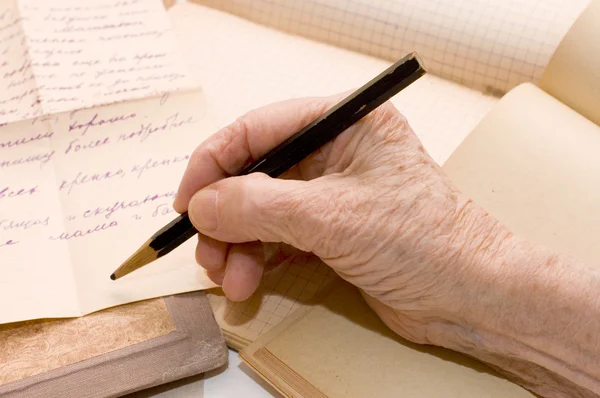 A mão velha escreve a carta um lápis — Fotografia de Stock