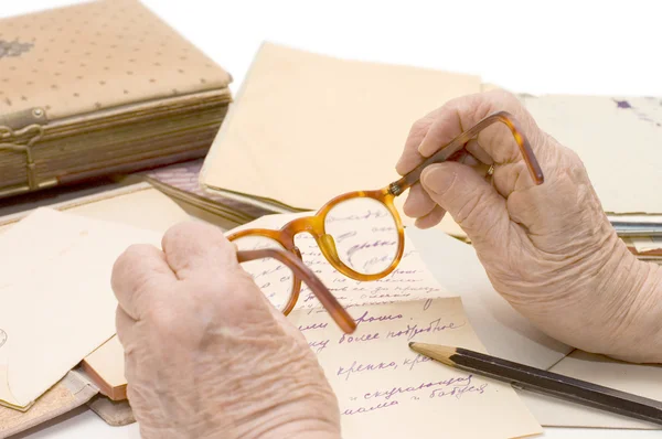 Mãos velhas segurar óculos, Lápis, carta — Fotografia de Stock