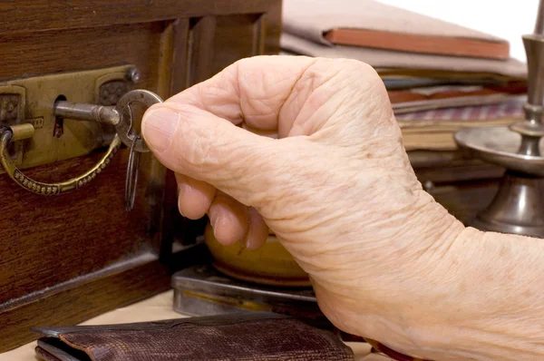 Oude vrouwelijke hand met een sleutel — Stockfoto