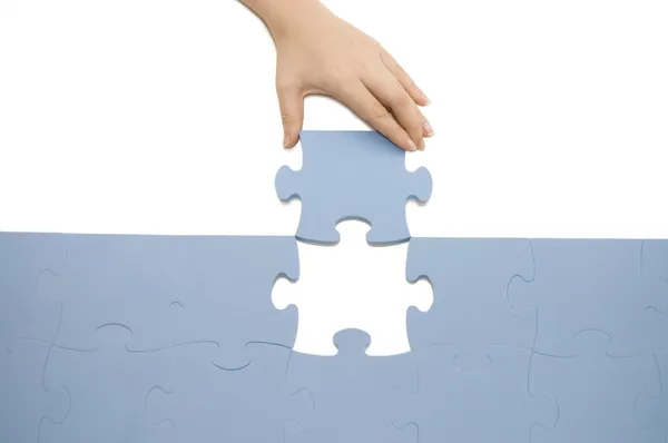 Hand collecting a part of a puzzle — Stock Photo, Image