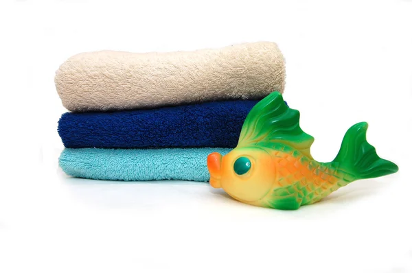Kombinerad färg handdukar med en leksak fisk — Stockfoto