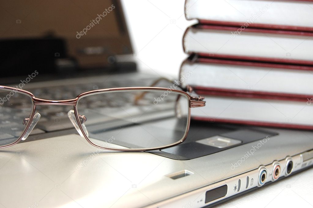 Eyeglasses and books on the laptop