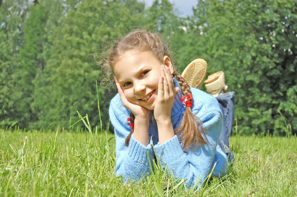 Dziewczyna układa się na zielonej trawie — Zdjęcie stockowe