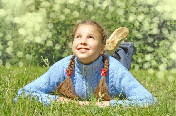 Девушка лежит на зеленой траве — стоковое фото