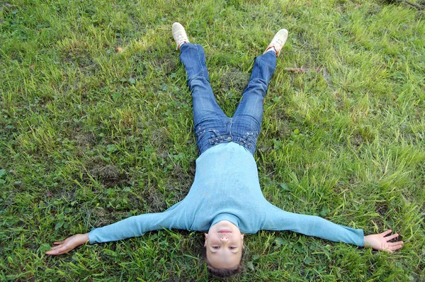 Девушка лежит на зеленой траве — стоковое фото