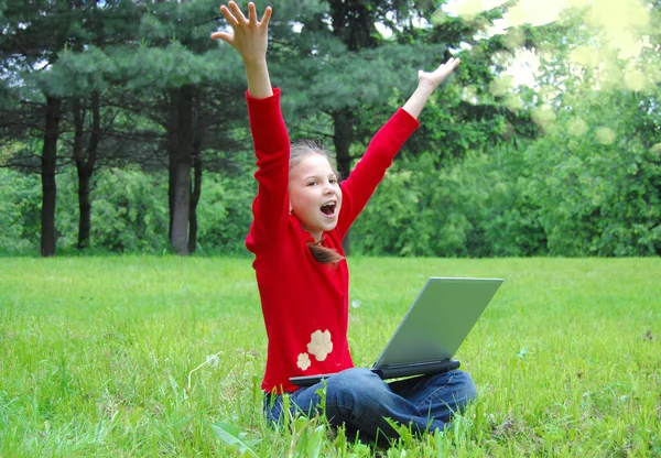 Başarı kız üstünde a laptop içinde yeşil çimen — Stok fotoğraf