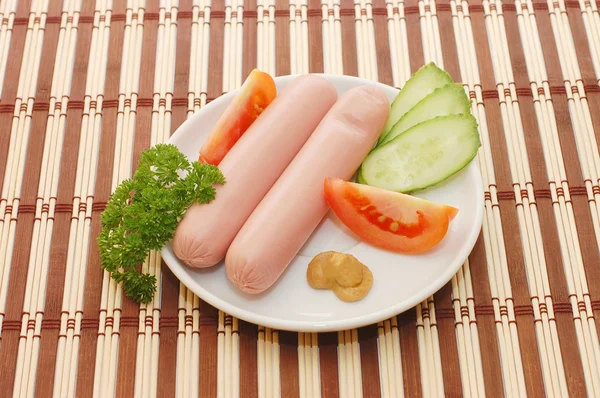 Salsicce su un piatto con verdure — Foto Stock