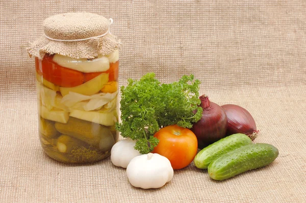 Fresh and tinned vegetables on a sacking — Stock Photo, Image