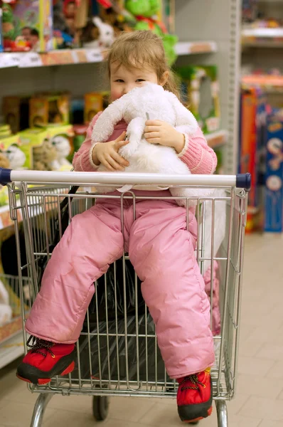 Het kleine meisje met een stuk speelgoed — Stockfoto