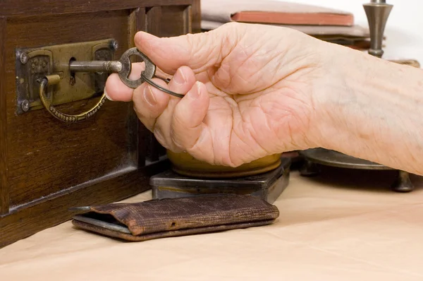 Old female hand with a key — Stock Fotó