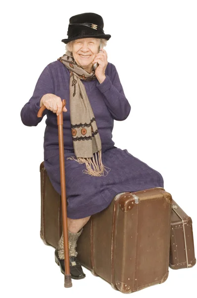 Starsza pani siedzi na walizkę — Zdjęcie stockowe