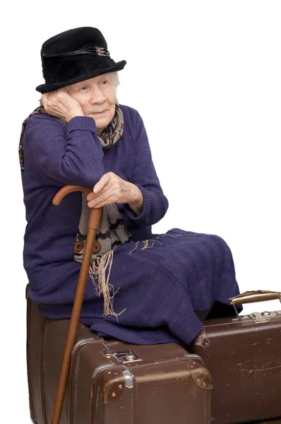 Старушка сидит на чемодане — стоковое фото