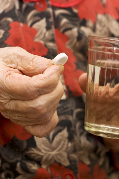 De oude vrouw drinkt een tablet — Stockfoto