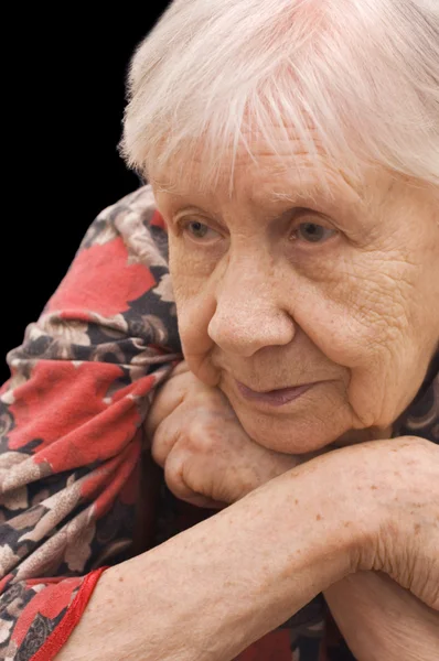 Die traurige alte Frau auf der schwarzen — Stockfoto