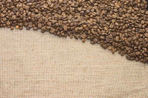 Brunt kaffe korn på en säckväv — Stockfoto