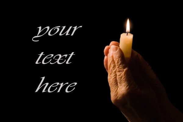 Old female hands with a candle — Stock Photo, Image