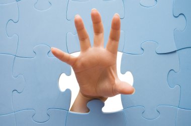 Female hand through a puzzle clipart