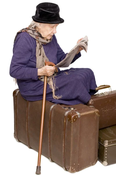Den gamla damen som sitter på en resväska — Stockfoto