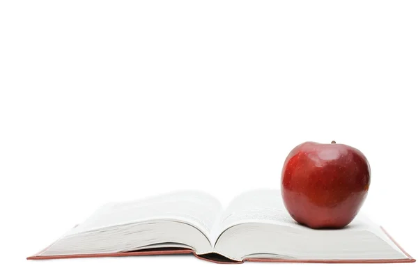 Красное яблоко на открытой книге — стоковое фото