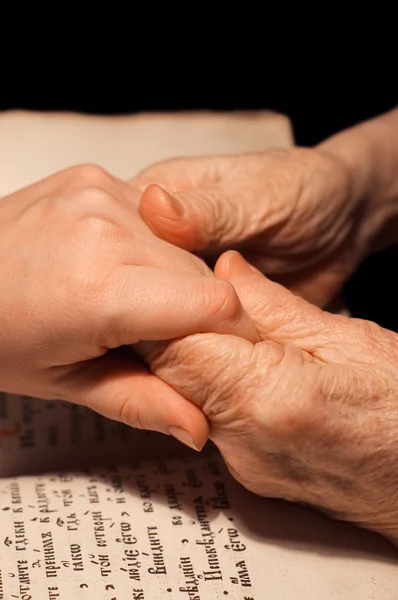 Starý a mladý ruce na Bibli — Stock fotografie