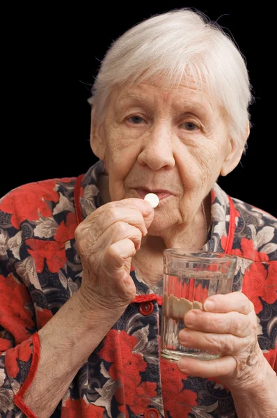 Стара жінка п'є таблетку — стокове фото