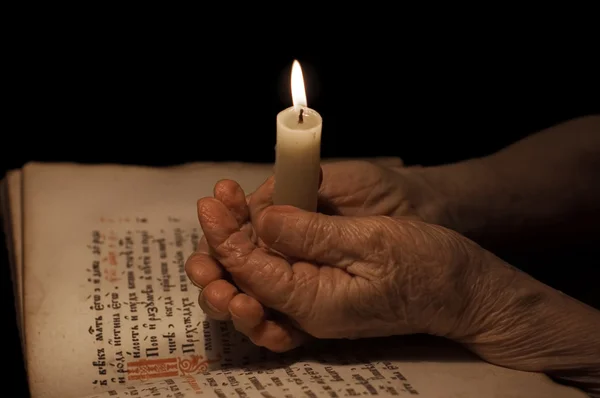 Руки старушки со свечой — стоковое фото