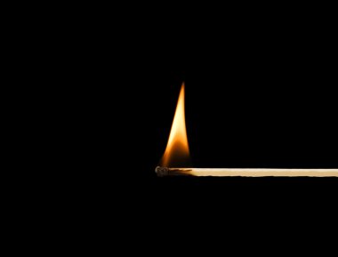 Burning match on a black background clipart