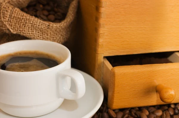 Vecchio macinacaffè, tazza e chicchi di caffè — Foto Stock