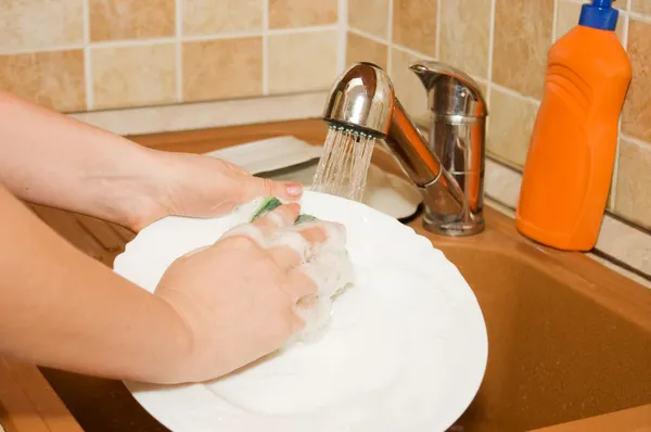 La mujer lava la vajilla en la cocina —  Fotos de Stock