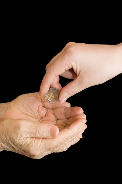 Jonge en oude hand met een munt — Stockfoto