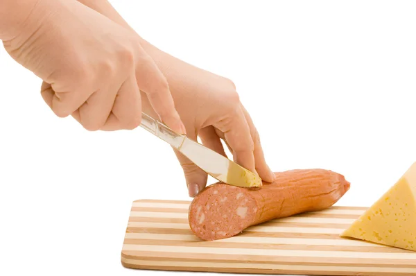 La mano con un coltello taglia la salsiccia — Foto Stock