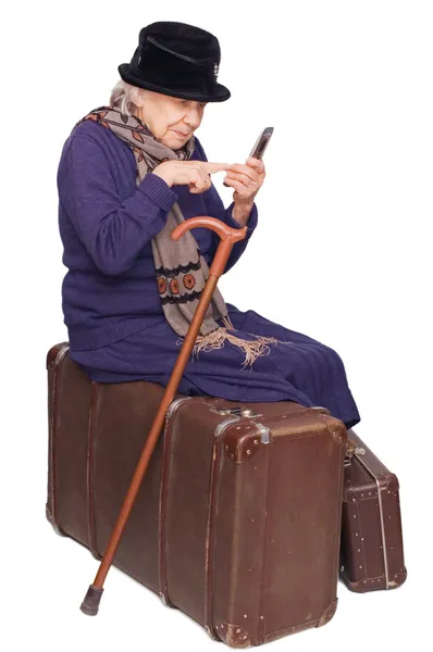 这位老太太坐在行李箱上 — 图库照片