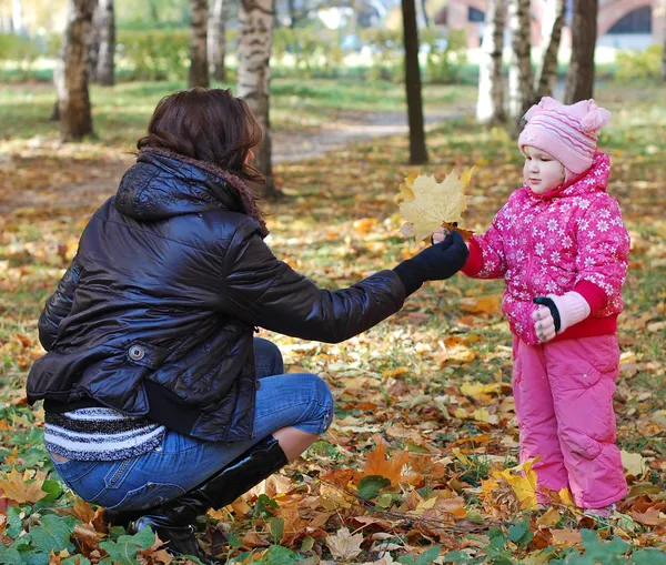 Мама с дочерью гуляют в осеннем парке — стоковое фото