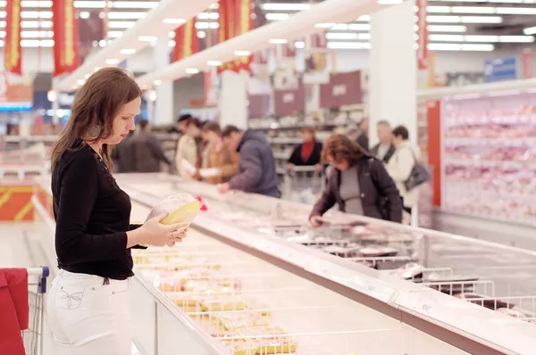 Girl buys a hen in a supermarket — Stock Photo, Image