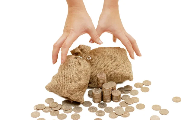 Mãos ao alcance de bolsas com moedas — Fotografia de Stock