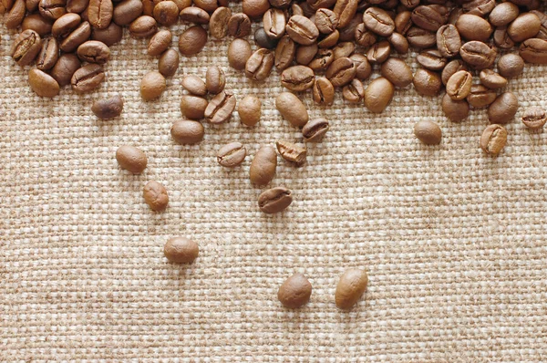 Кофейные зерна на текстуре мешковины — стоковое фото