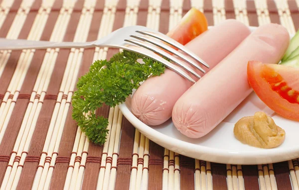 Sausages on a plate with vegetables — Stock Photo, Image