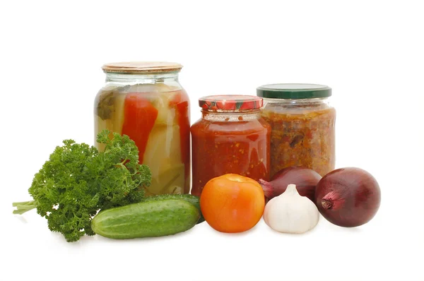 Свежие и консервированные овощи на белом — стоковое фото