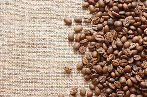Granos de café en una textura de arpillera —  Fotos de Stock